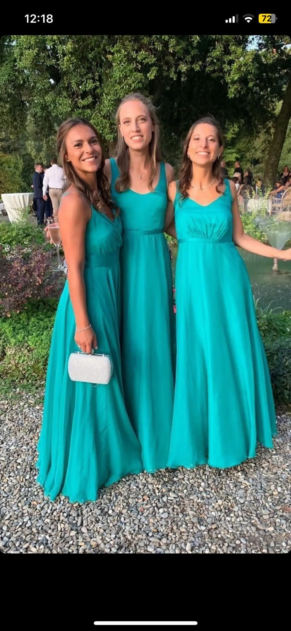 Tre damigelle in abiti color verde acqua posano per una foto.