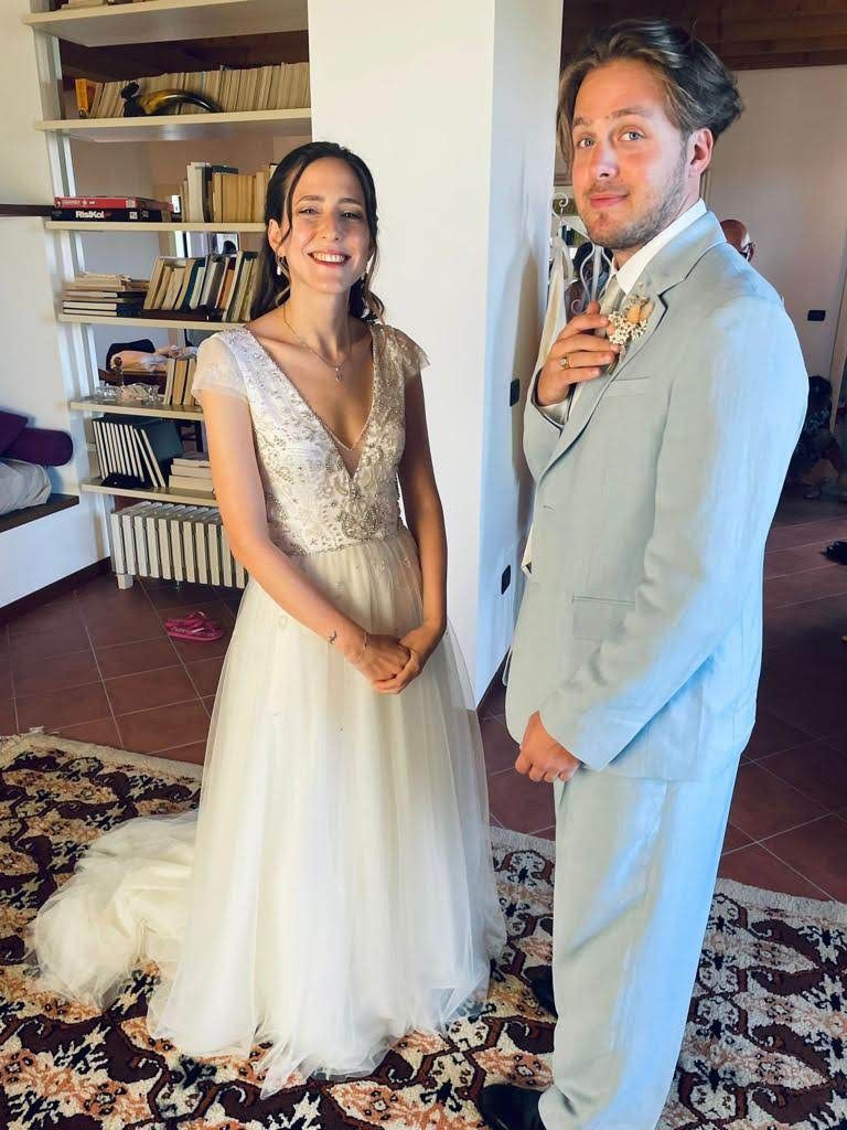 Una sposa e uno sposo sono in piedi uno accanto all'altro in una stanza.