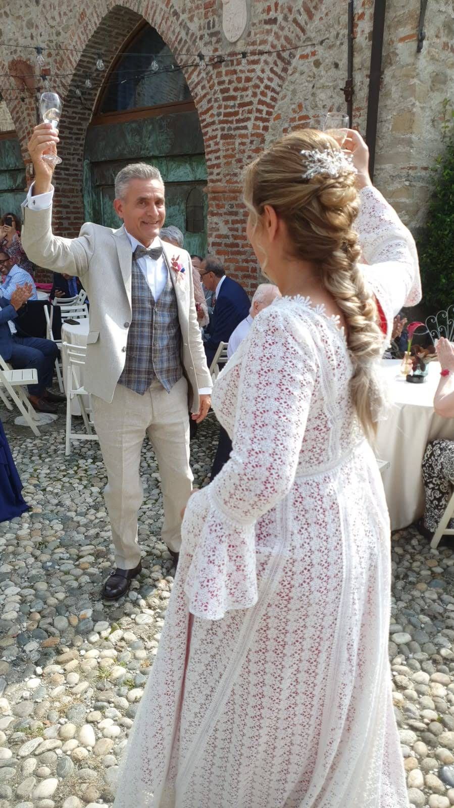 Una donna in abito bianco balla con un uomo in abito.