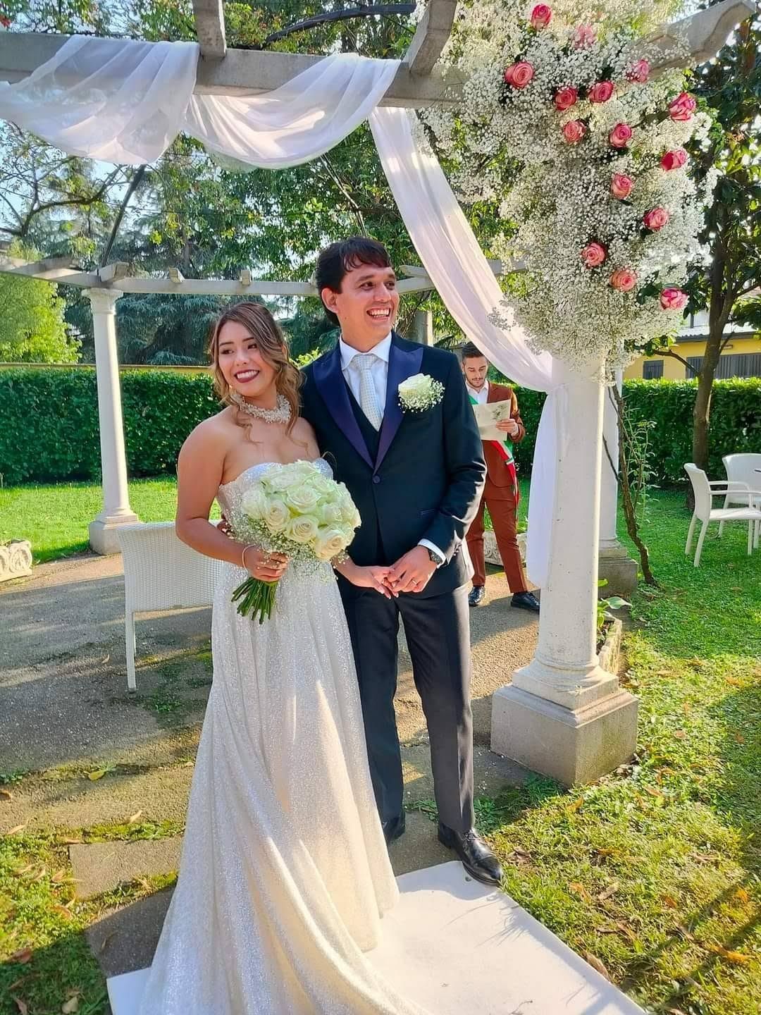 Una coppia di sposi posa per una foto durante la cerimonia nuziale.