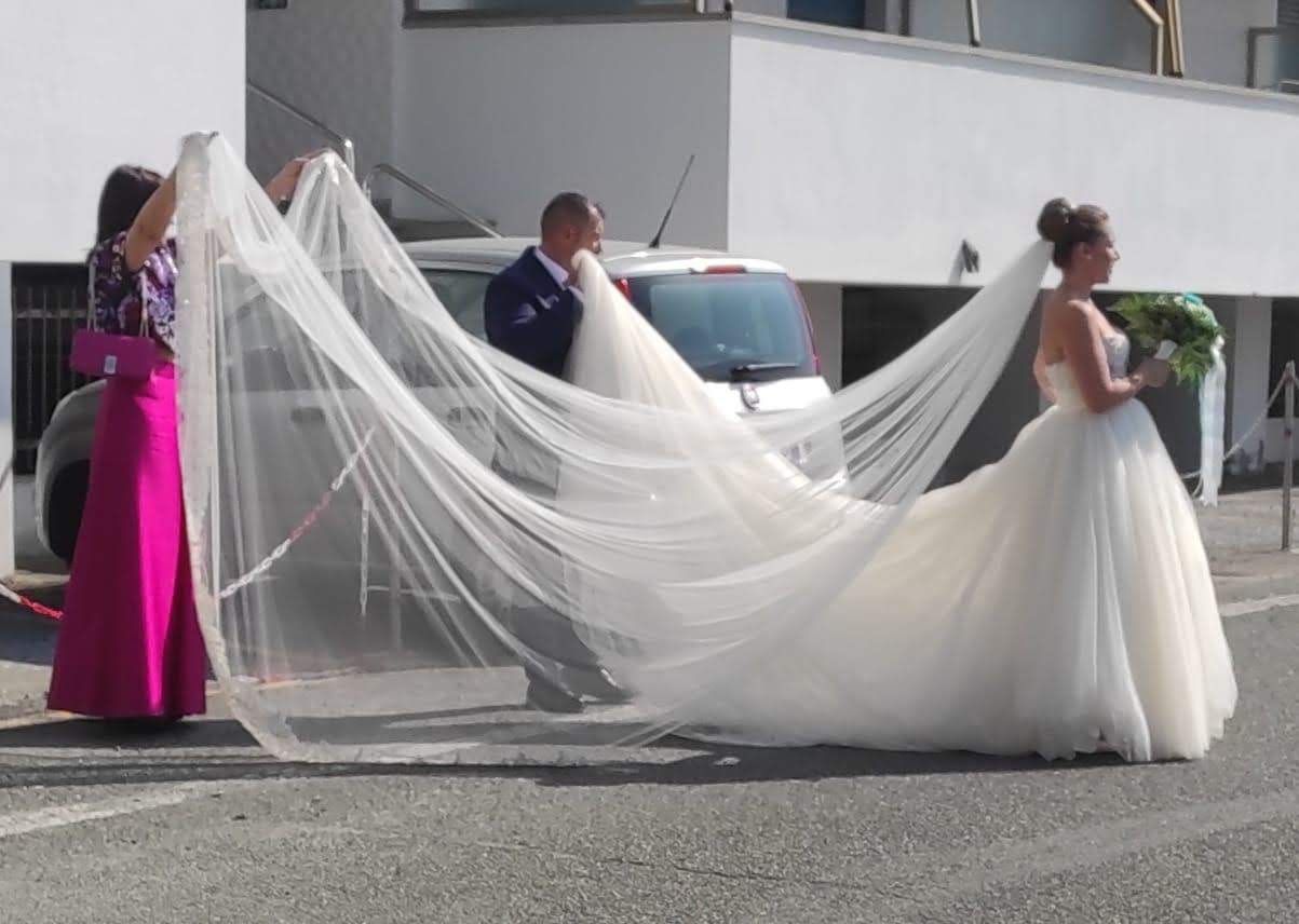 Una sposa in abito da sposa con un lungo velo