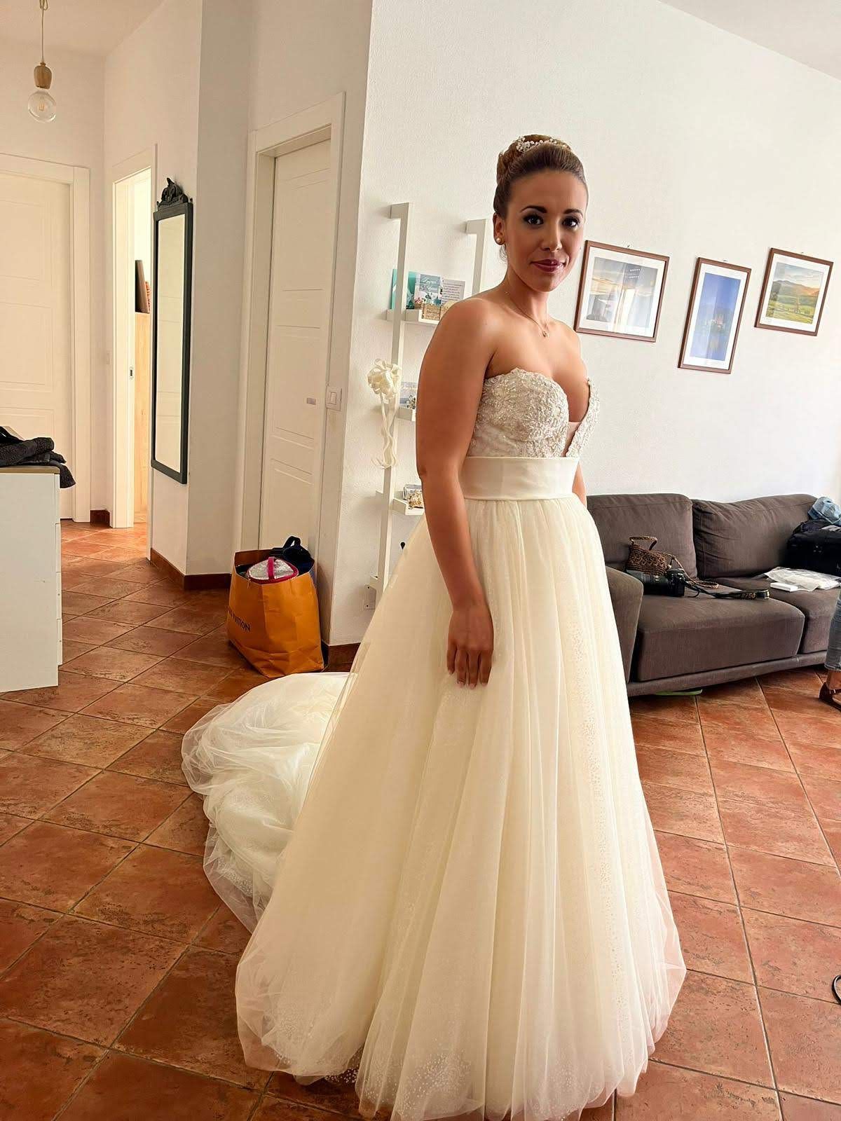 Una donna in abito da sposa è in piedi in un soggiorno.