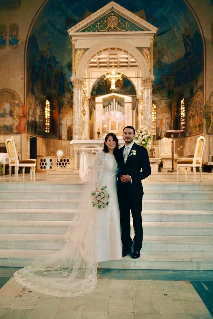 Una coppia di sposi posa per una foto in una chiesa.