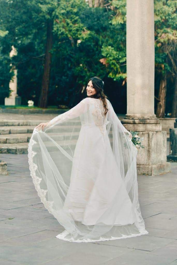 La sposa indossa un lungo velo e un abito da sposa.