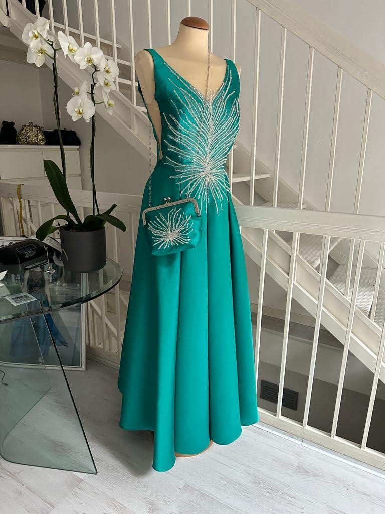 Un vestito verde è su un manichino davanti a una scala.