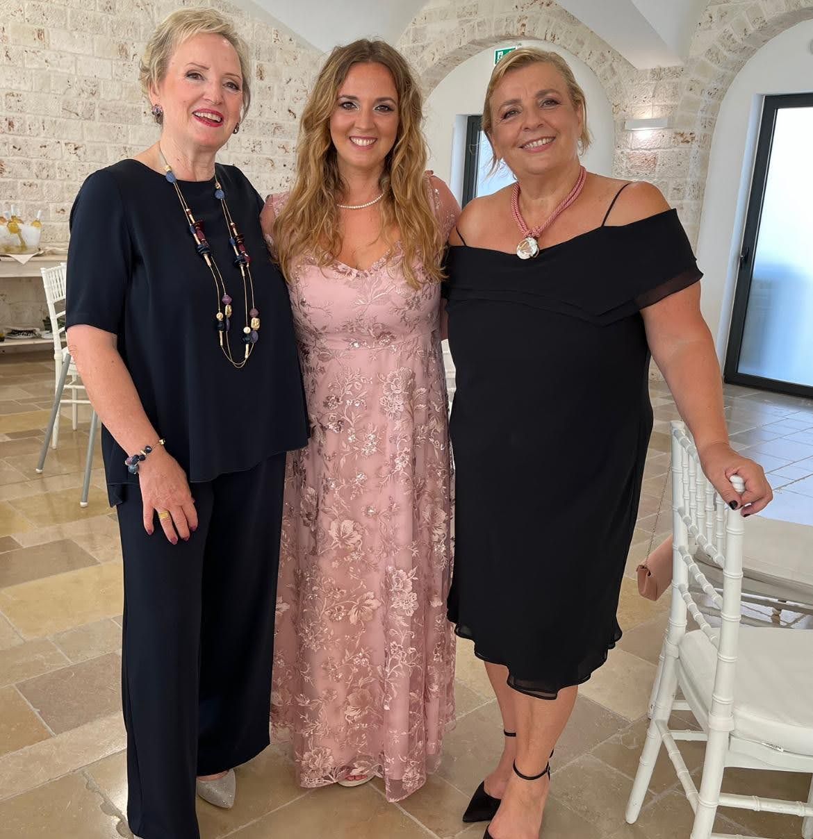 Tre donne posano insieme per una foto in una stanza