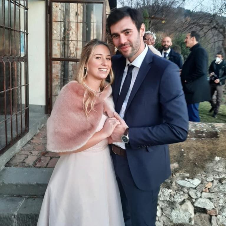 Una sposa e uno sposo posano per una foto davanti a un edificio