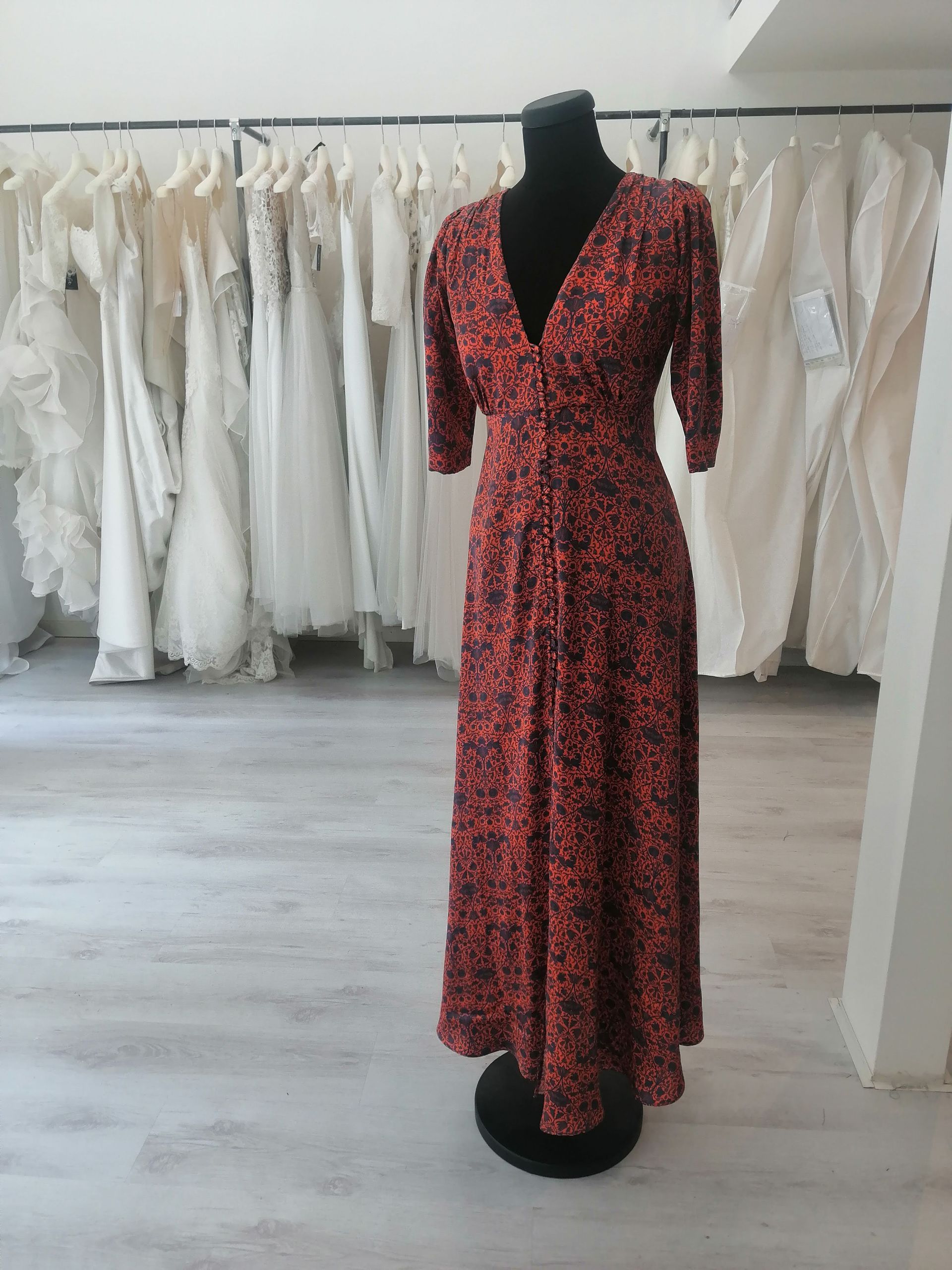 Un vestito rosso è su un manichino in un negozio.