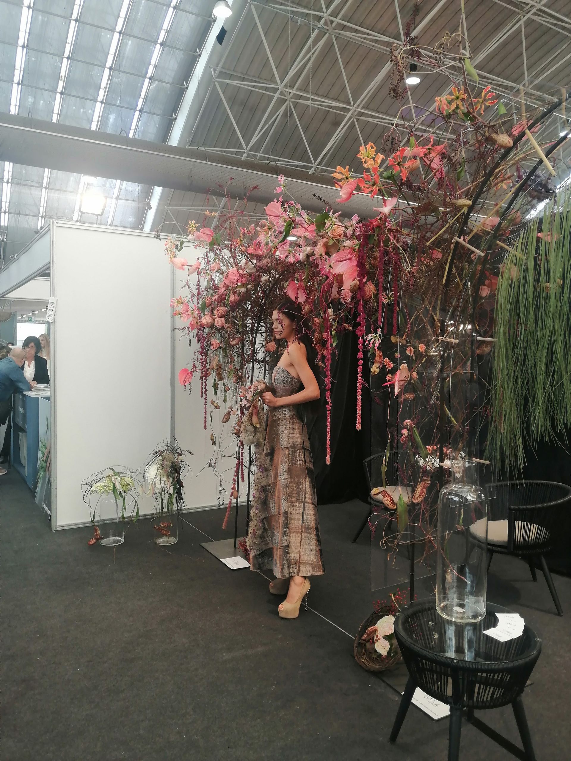 Una donna è in piedi davanti a un albero con fiori rosa