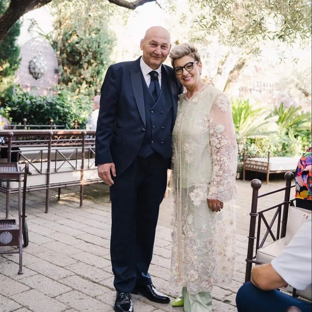 Un uomo in giacca e cravatta sta accanto a una donna in abito bianco