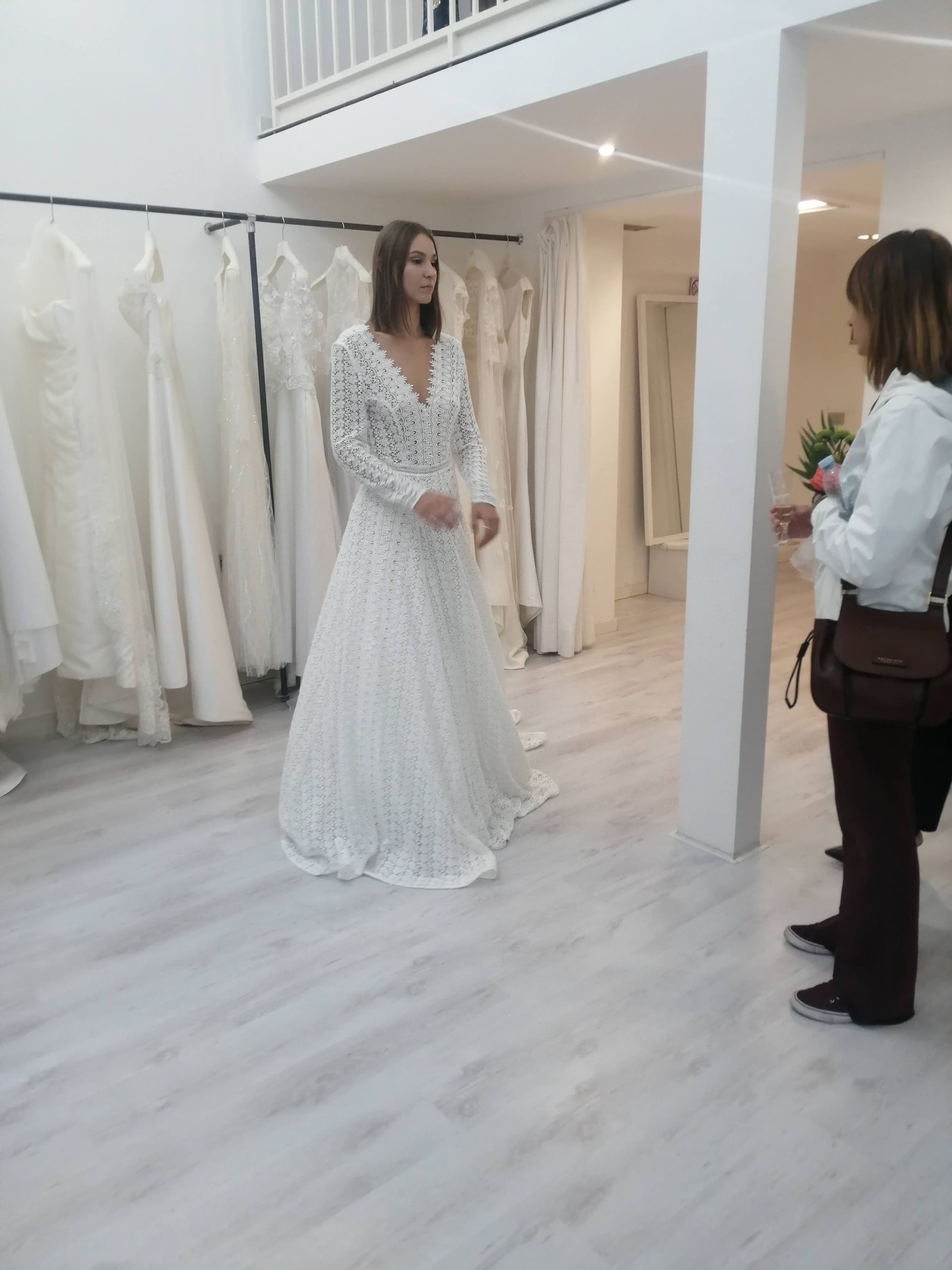Una donna in abito da sposa è in piedi in una stanza con altre donne