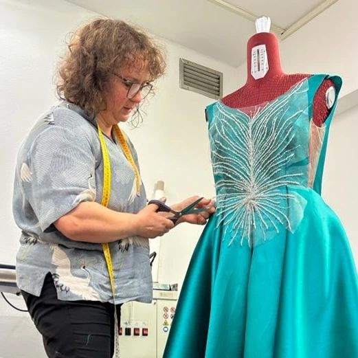 Una donna sta misurando un vestito su un manichino