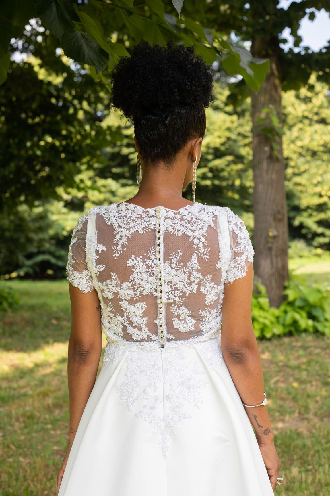 Viene mostrata la schiena di una donna in abito da sposa.