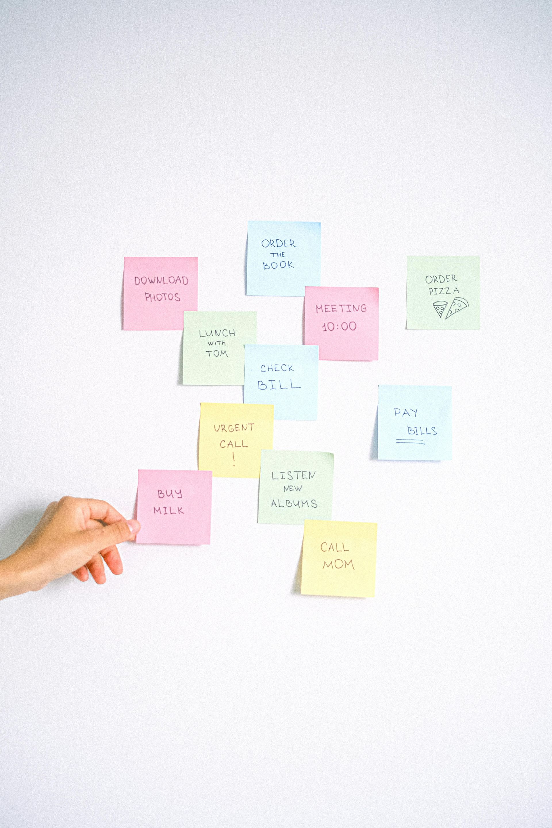 multiple sticky notes on a wall with action items