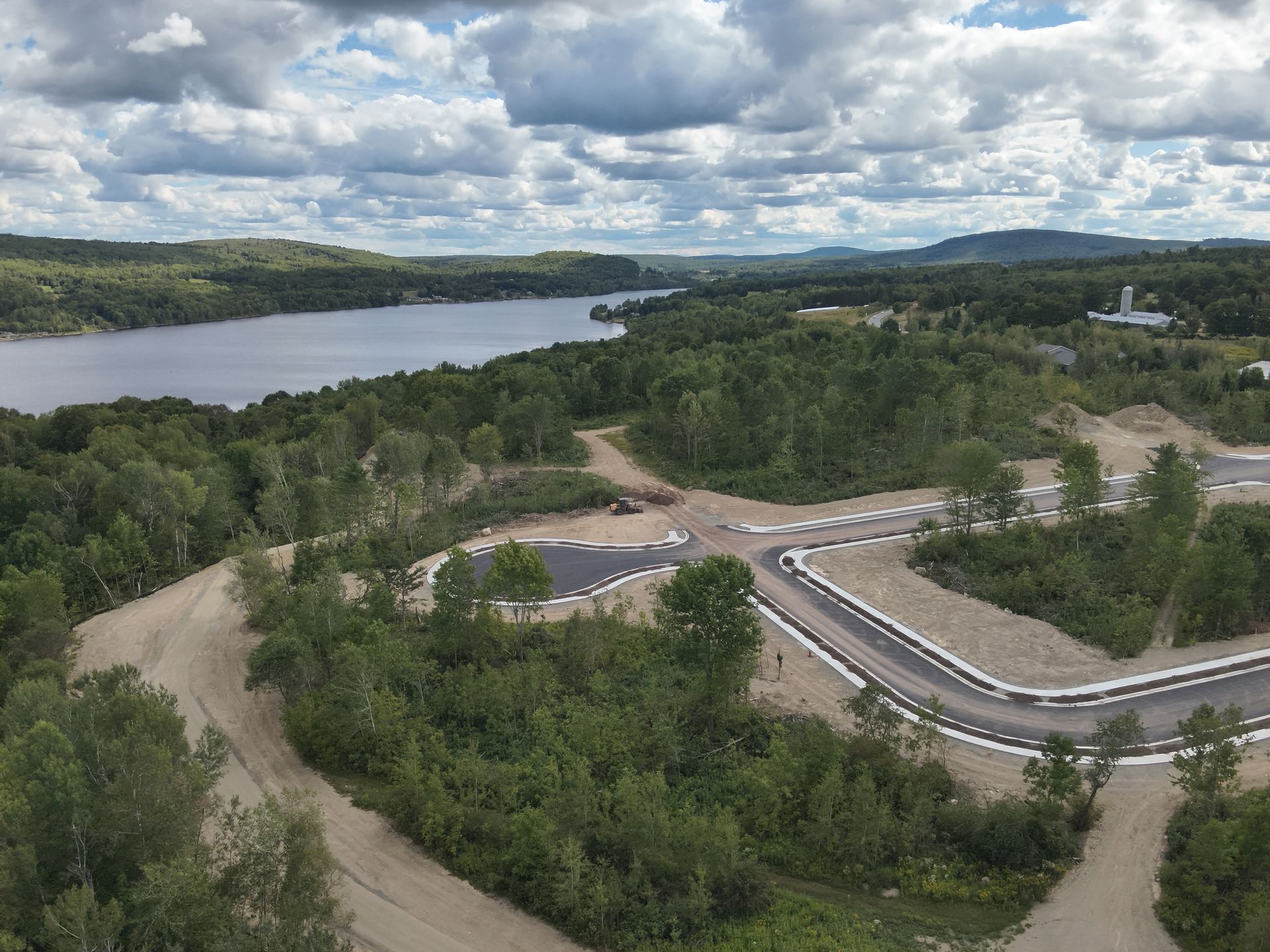 Architectural blueprints and hard hat on a wooden table with spring blossoms in the background.