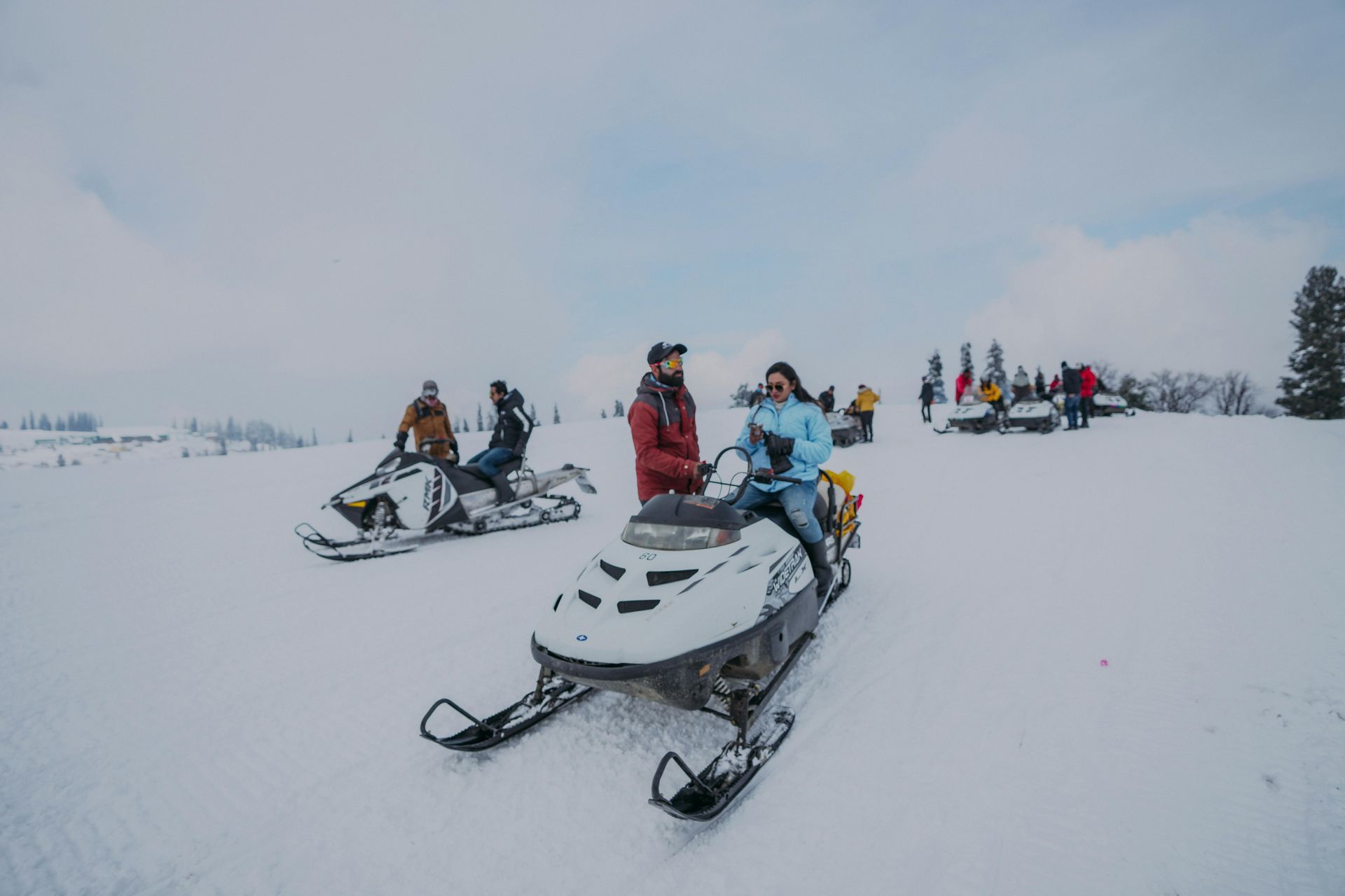 A man is riding a snowmobile through the snow.