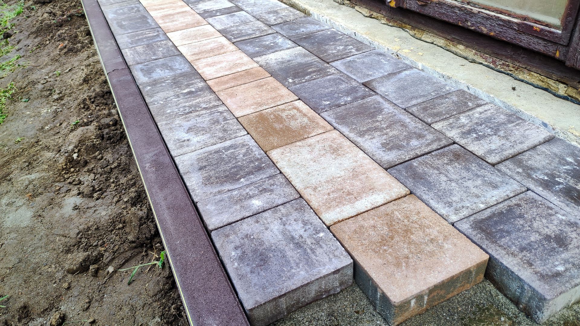 Paving stones are laid on the ground during a home renovation. Paving stones are laid on the ground during a home renovation.
