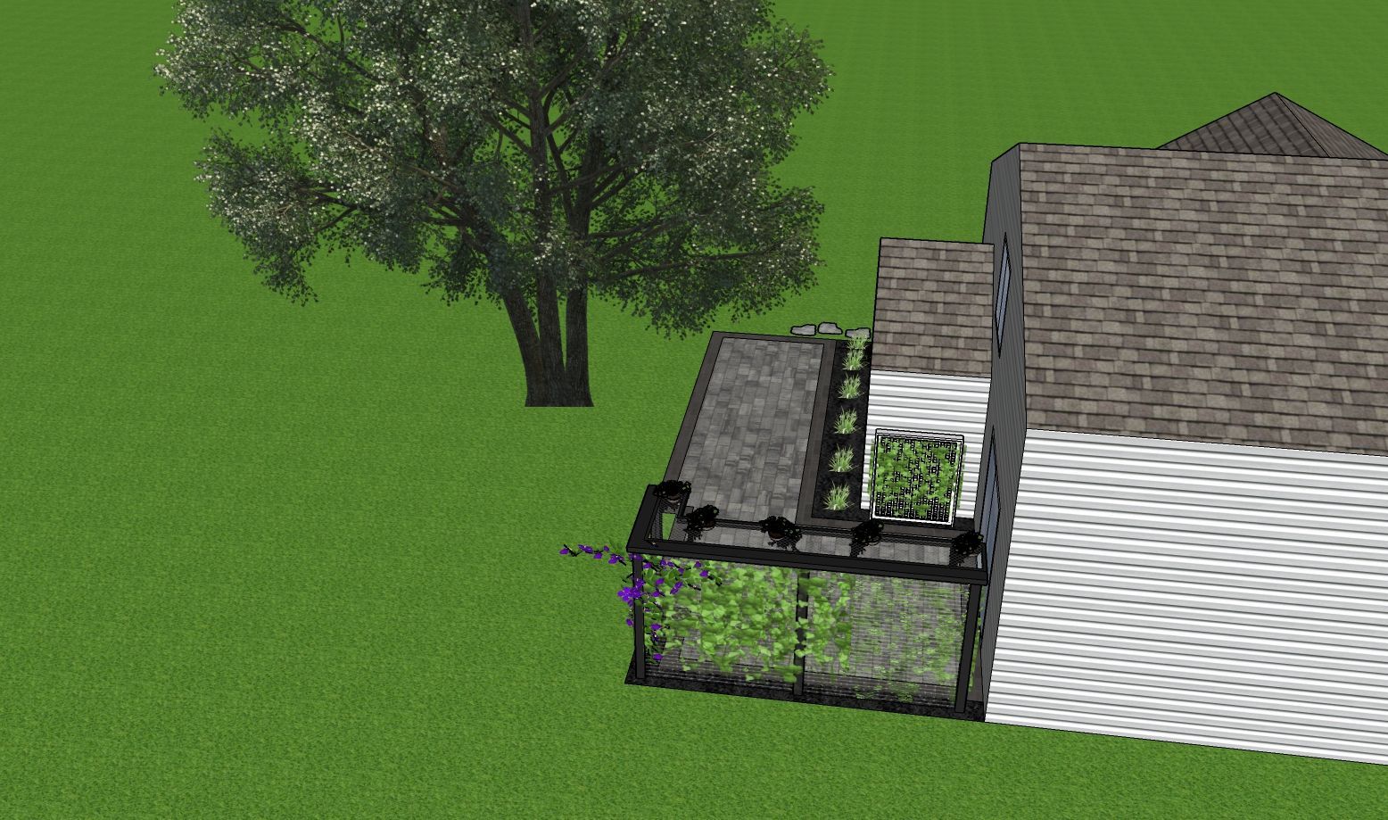 Green grassy yard with a tree and a house with a small greenhouse.