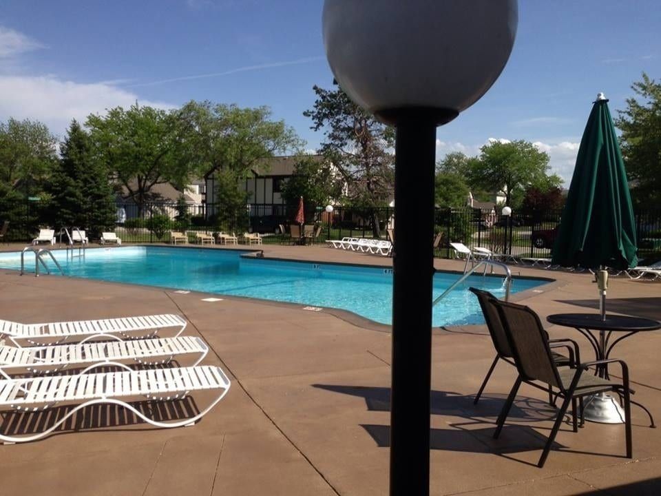 Outdoor swimming pool with lounge chairs and umbrellas on a sunny day
