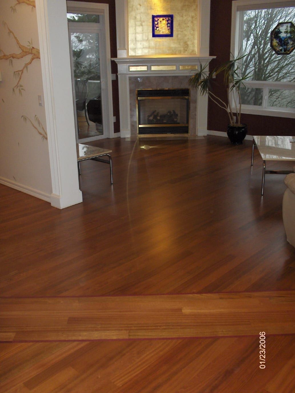 Living room with hardwood floors, fireplace, and large windows.