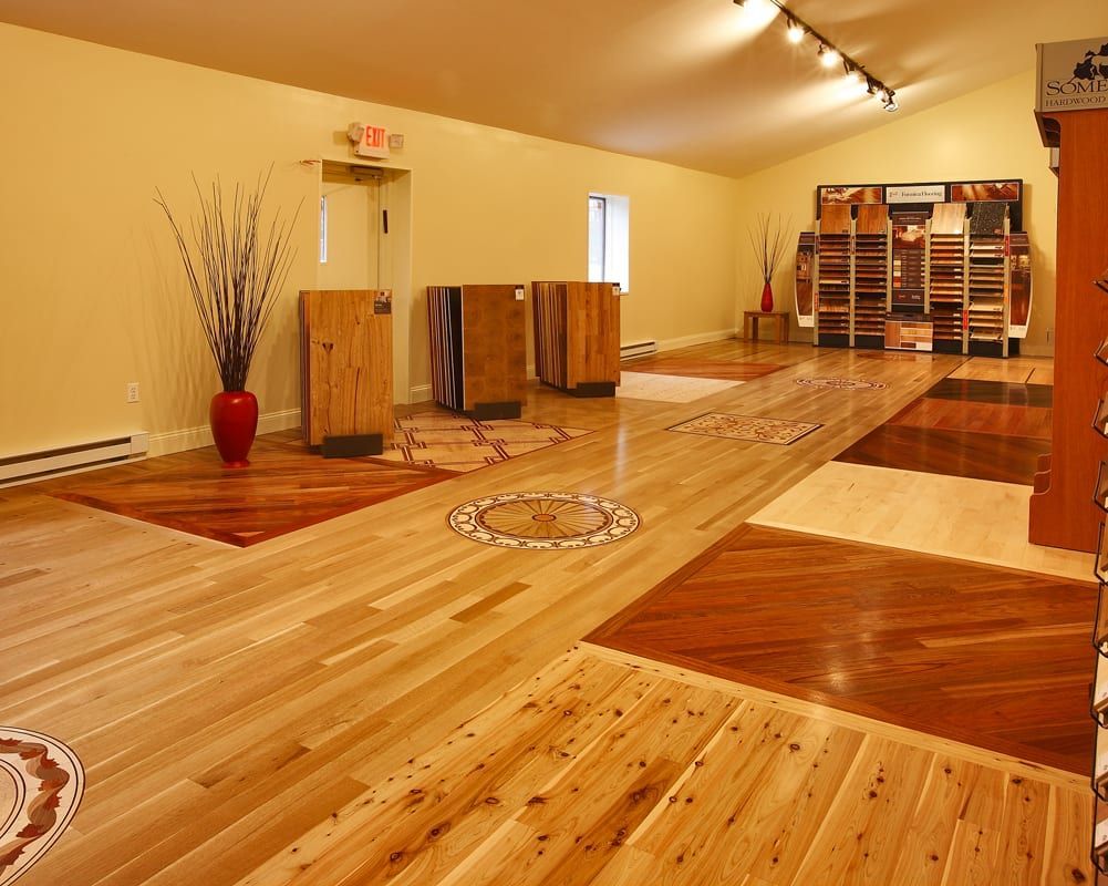 Empty yoga studio with wood floors, warm lighting, and mats arranged in rows