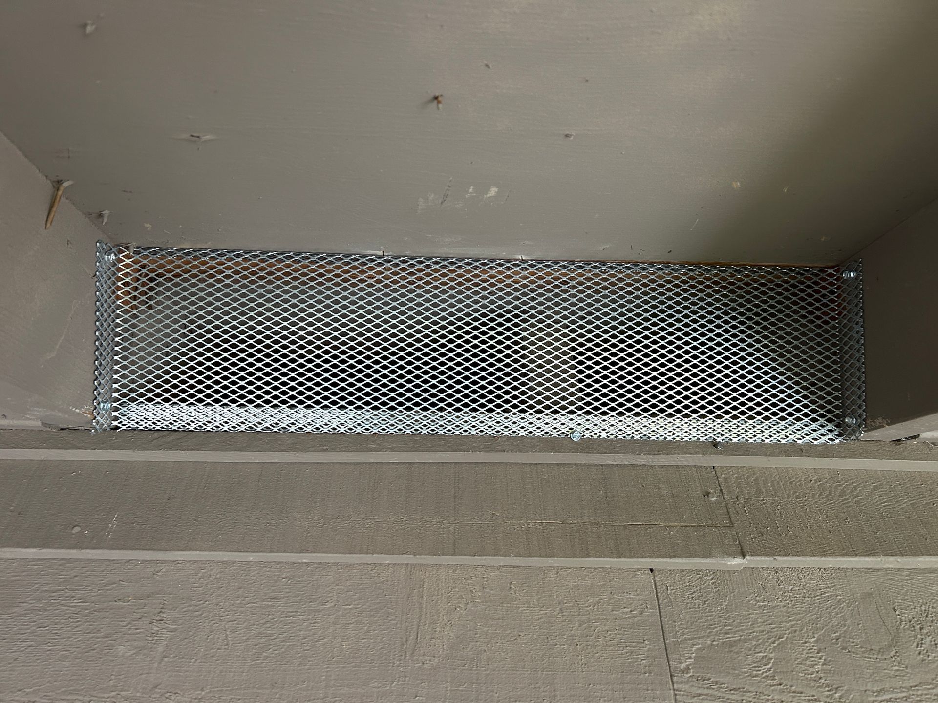 A metal grate is sitting on top of a concrete floor.