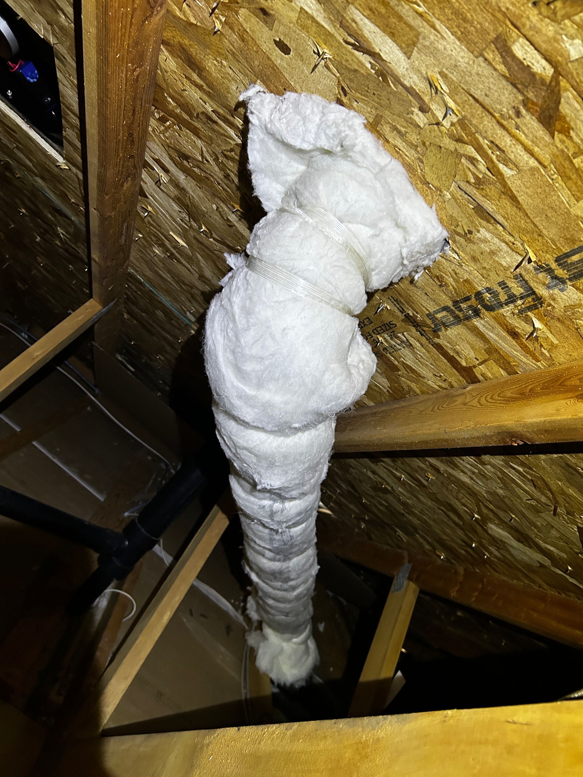 A piece of insulation is hanging from the ceiling of a room