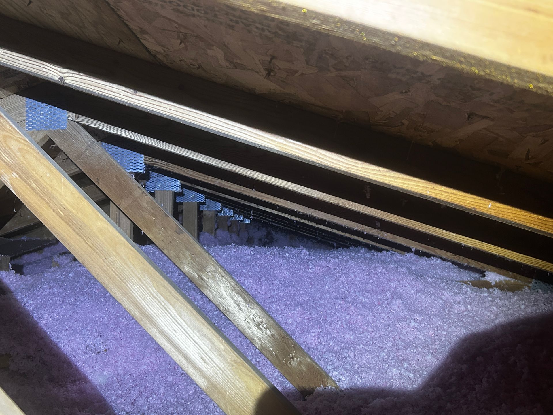There is a lot of purple insulation in the attic.
