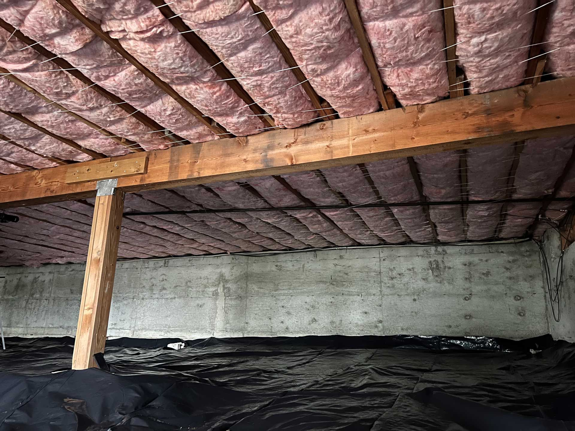 A man is standing on a scissor lift in a building under construction.