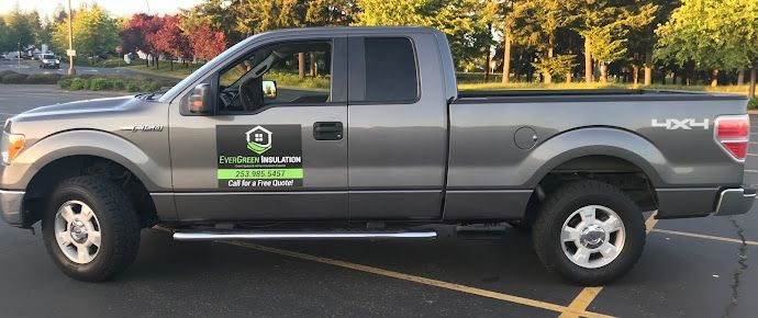 A gray pickup truck is parked in a parking lot.