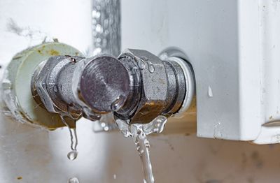 A close up of a leaking pipe with water coming out of it.