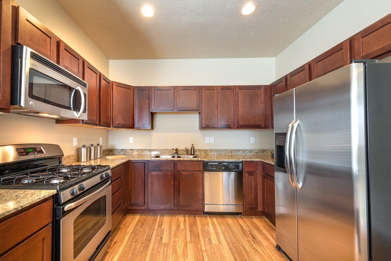 Kitchen with stainless steel appliances, granite counters, and dark wood cabinets.