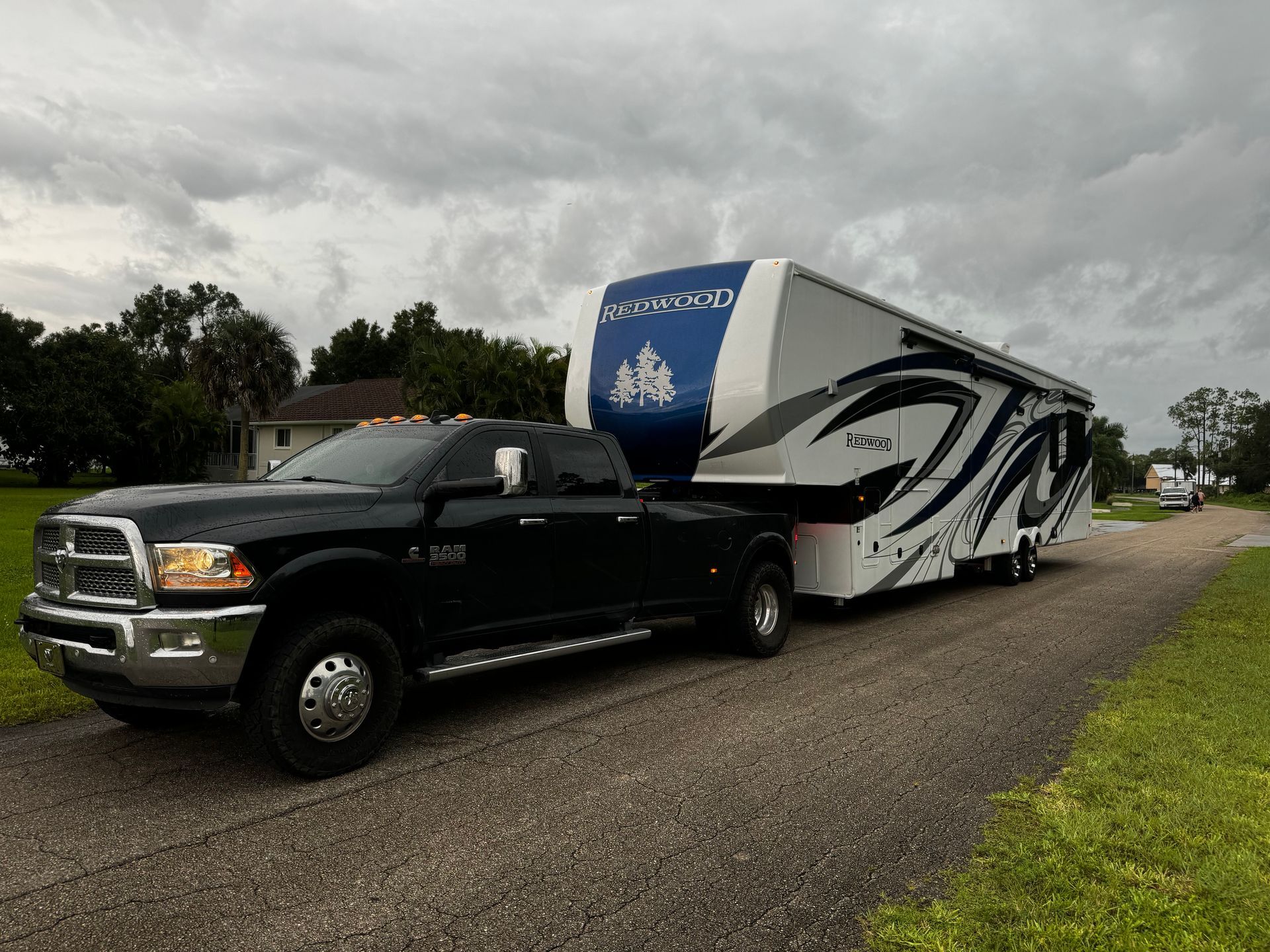 A truck is towing a trailer down a road.