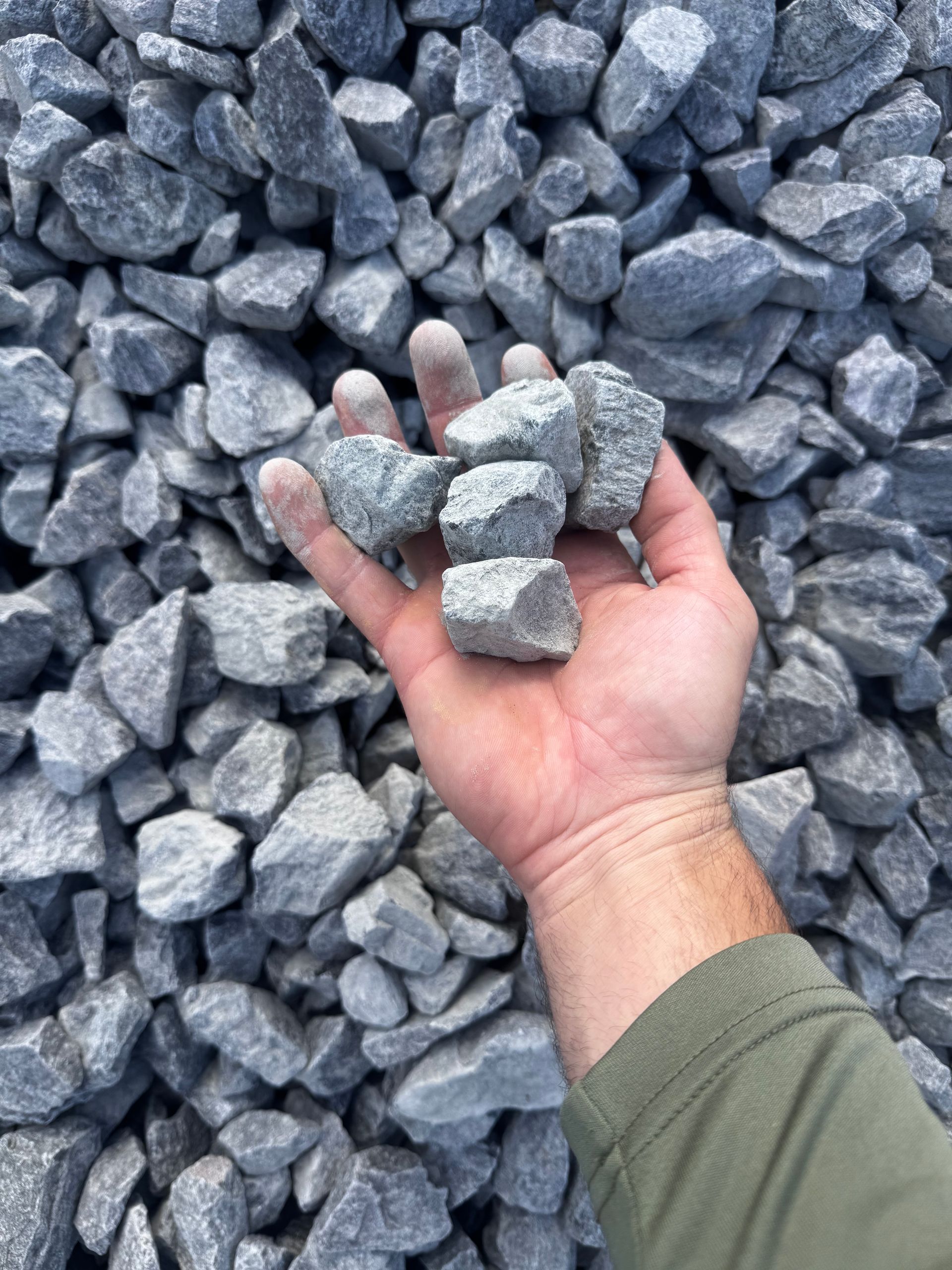 A person is holding a pile of rocks in their hand.