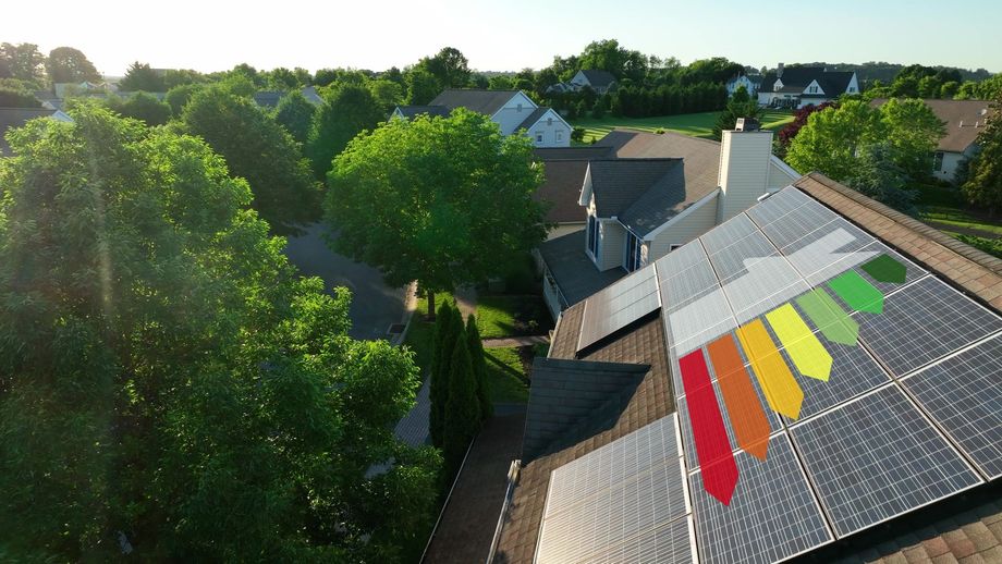 Solar panels on a house roof, with an energy efficiency graphic overlayed. Green trees surround the house.