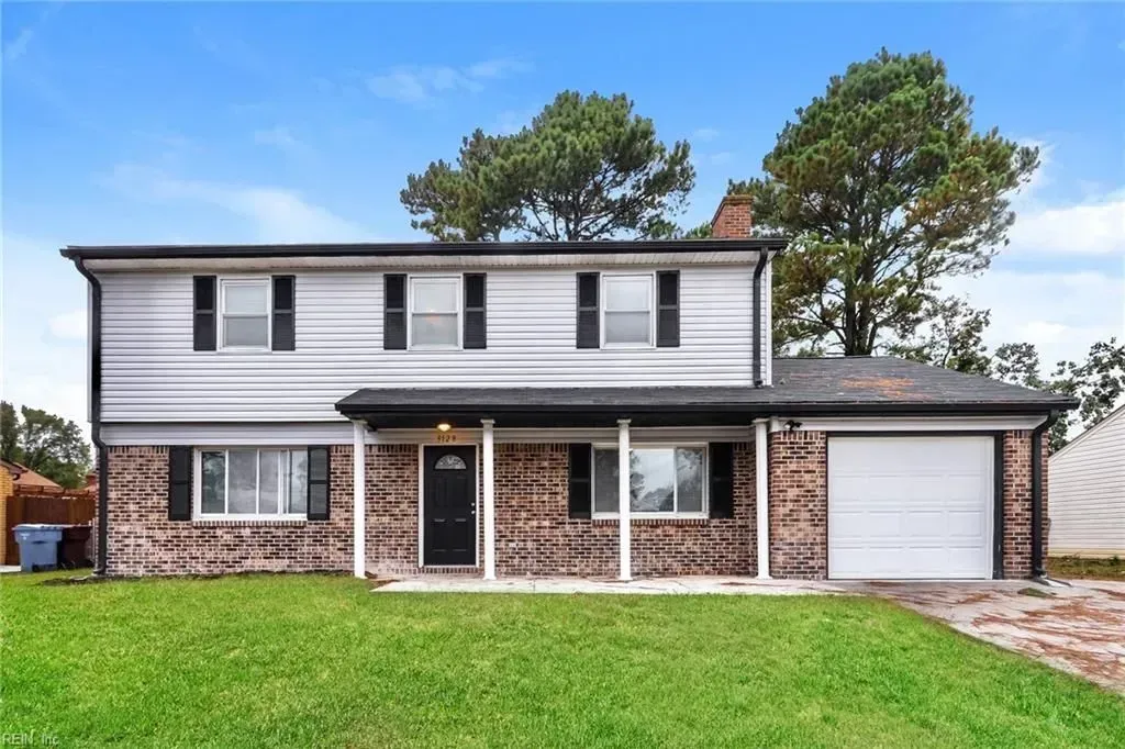 Two-story house with gray siding, brick facade, and a one-car garage. 