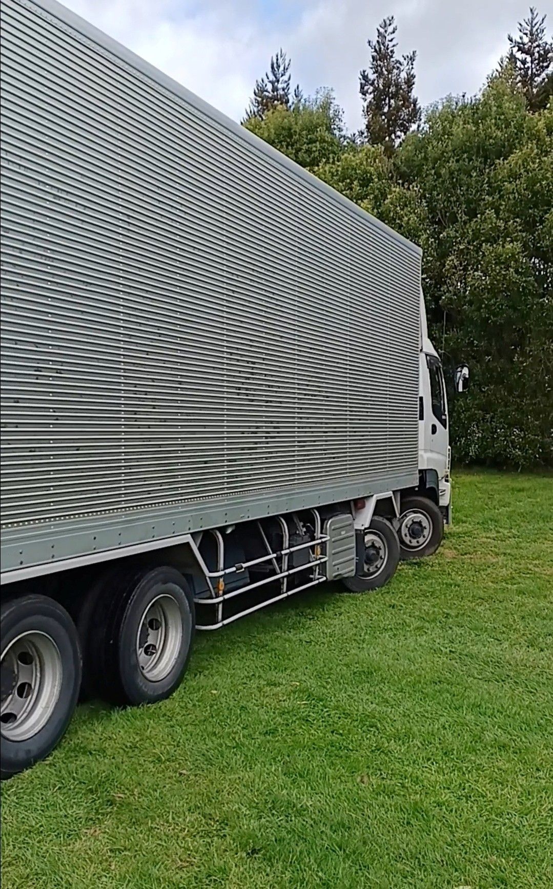 Delivery worker loading boxes into a truck. He's smiling, wearing a blue shirt and hat. Outdoors. Delivery worker loading boxes into a truck. He's smiling, wearing a blue shirt and hat. Outdoors.