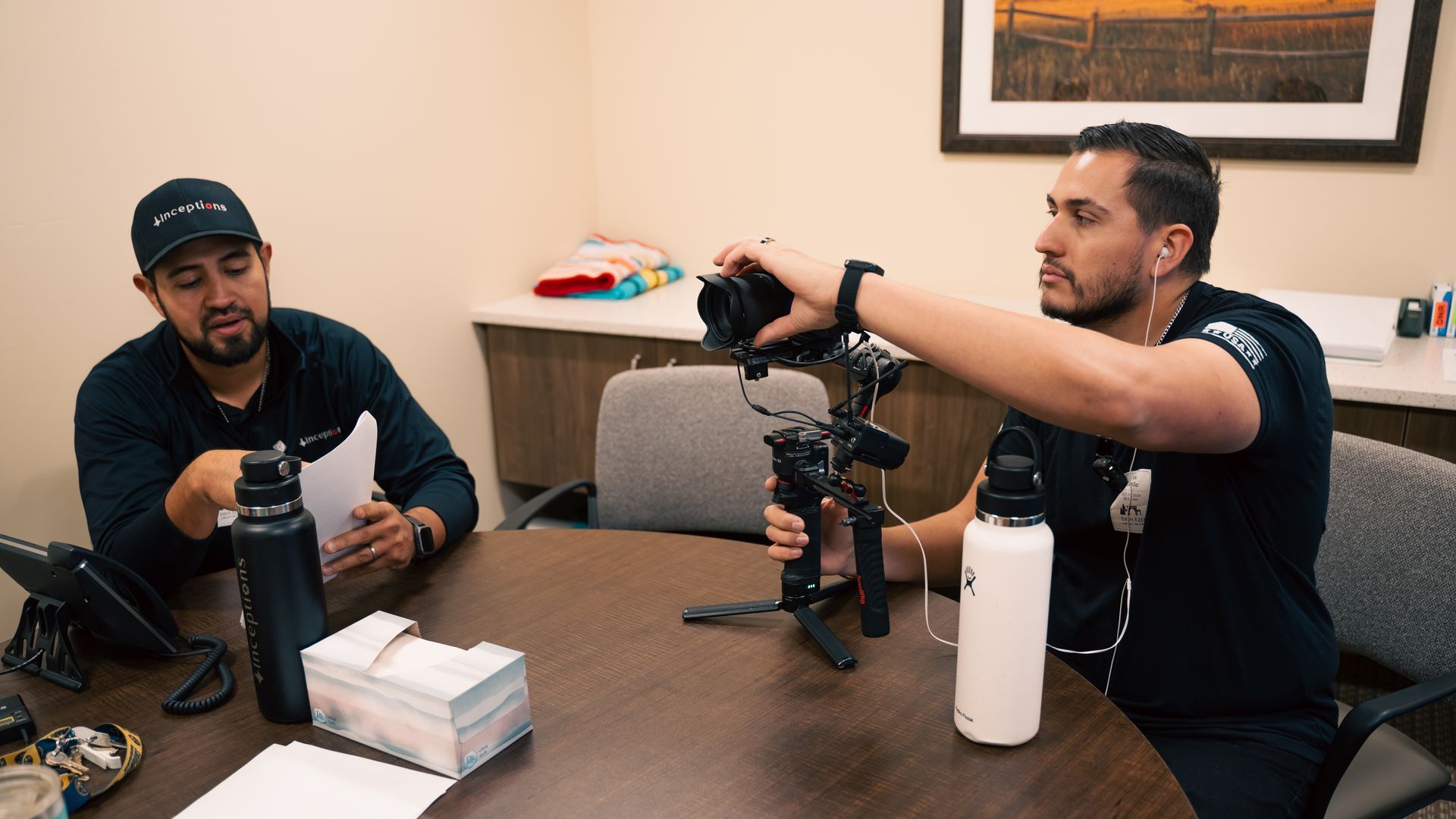 Monico & Erick are sitting at a table with a camera.