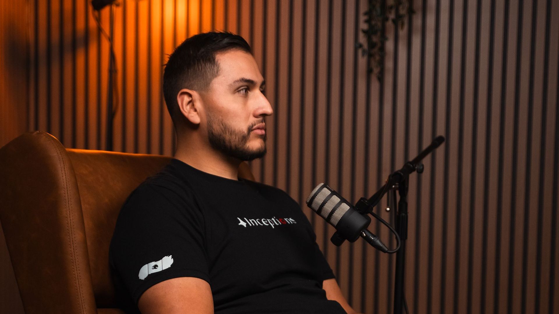 A man is sitting in a chair in front of a microphone.