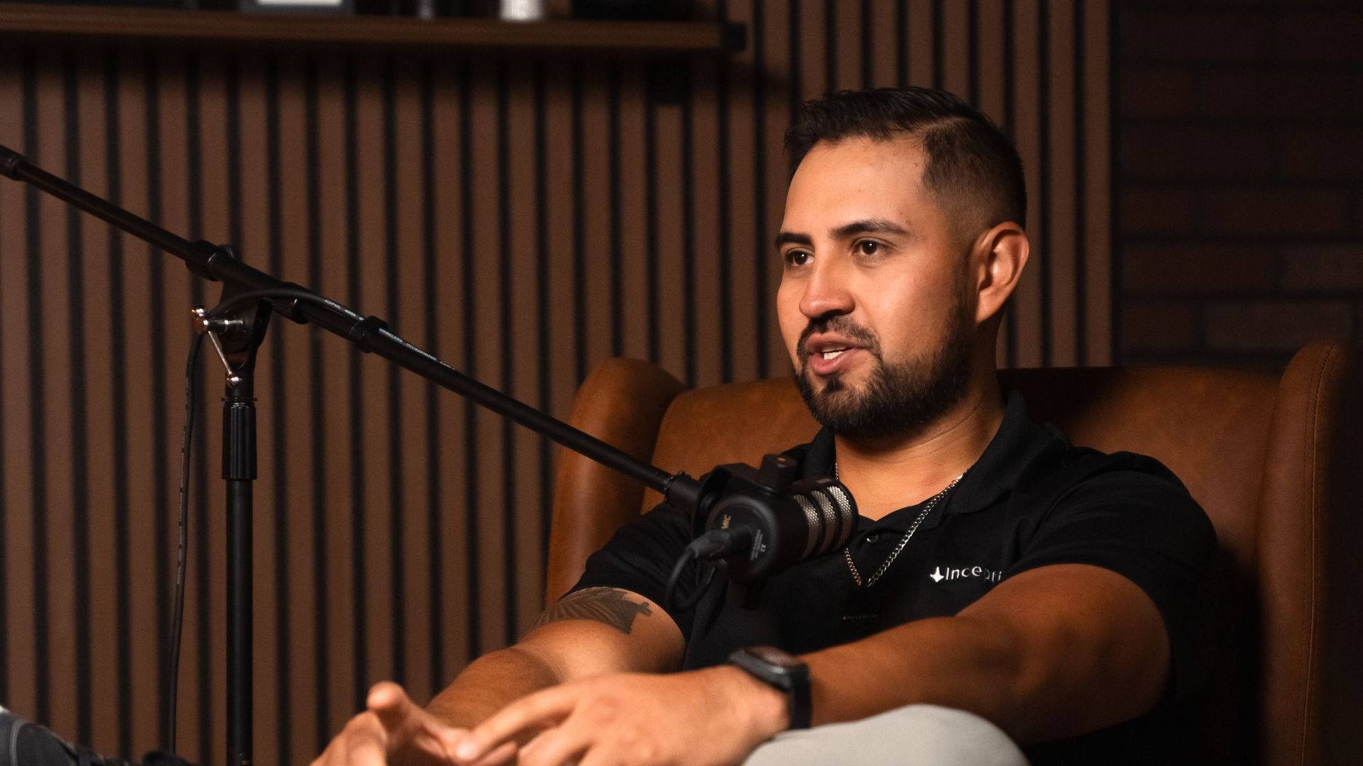A man is sitting in a chair in front of a microphone.