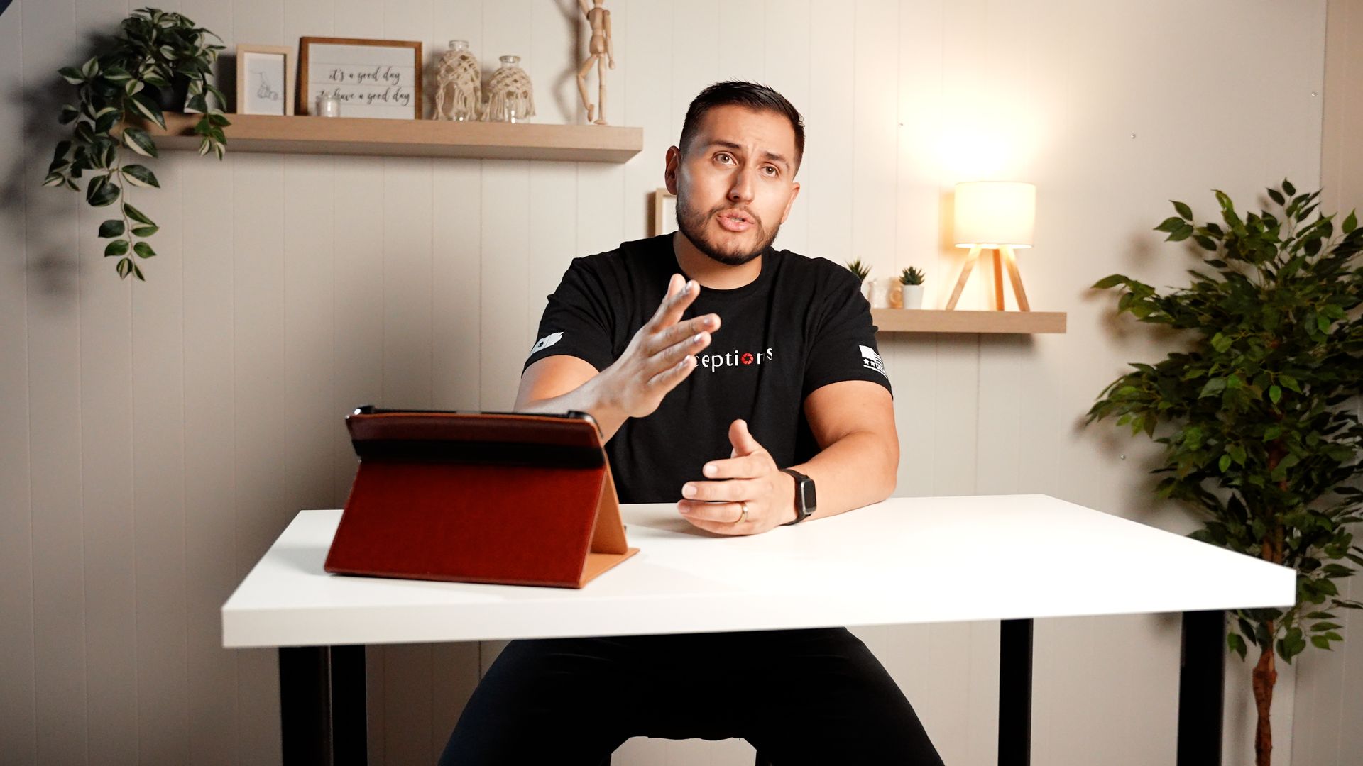 A man is sitting at a desk with a tablet on it.