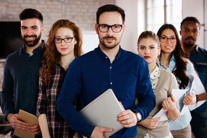 Group of diverse business professionals, standing together, serious expressions, holding documents.