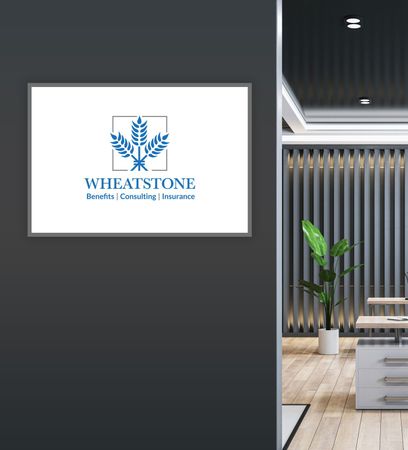 A framed Wheatstone Benefits logo on a gray wall next to an office interior with a plant.