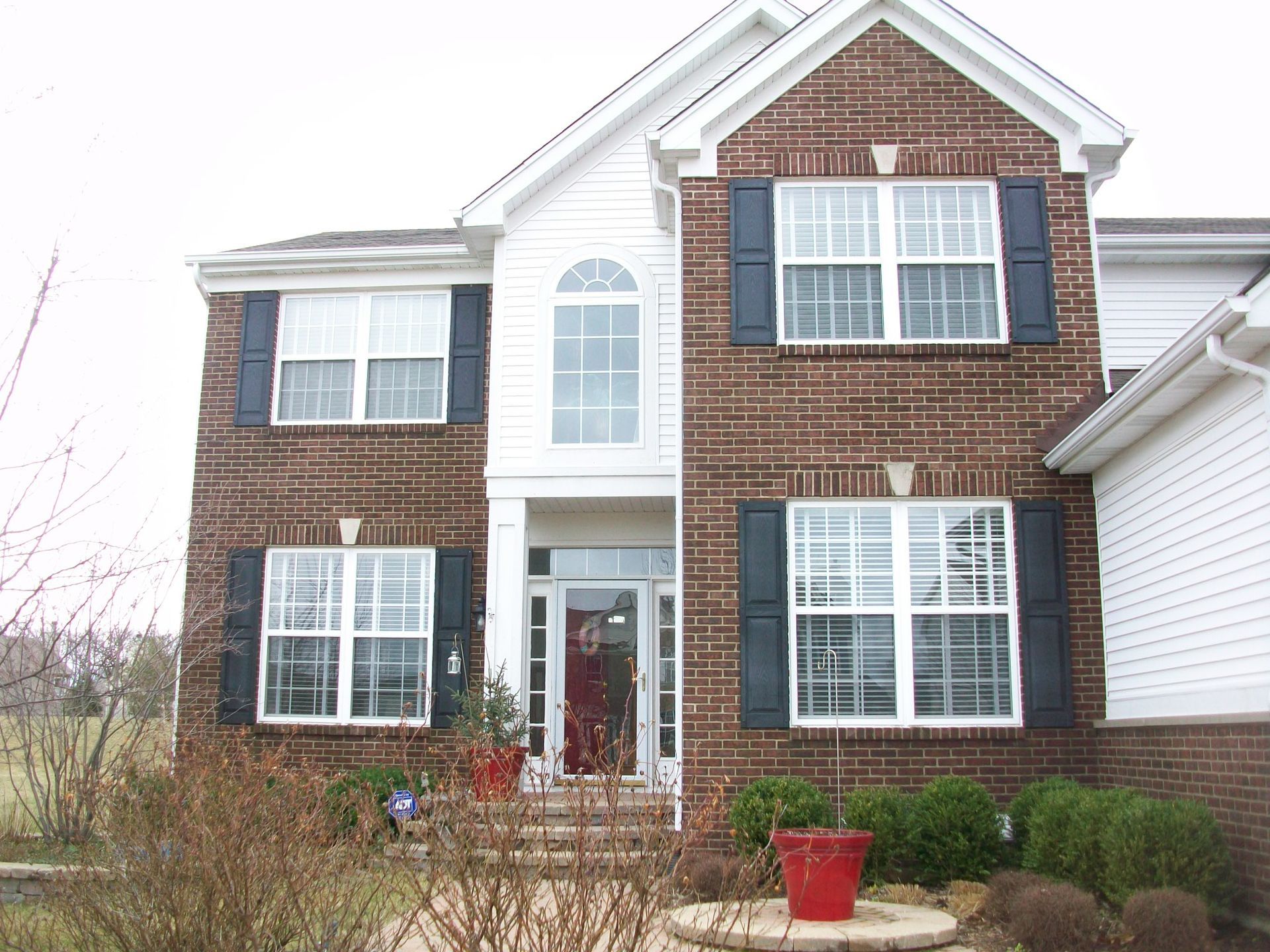 A brick house with white trim and black shutters