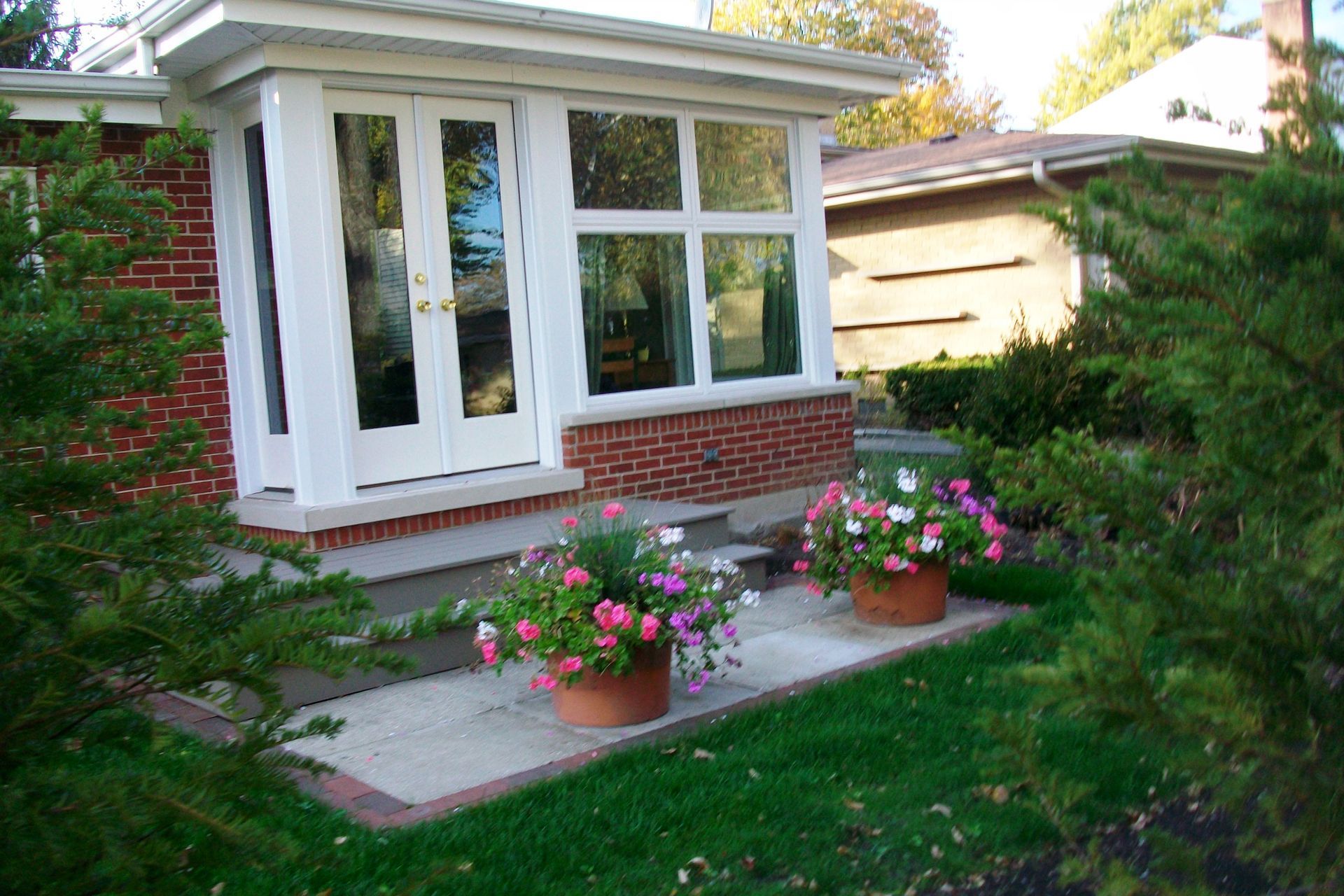 A house with a porch and flowers in front of it