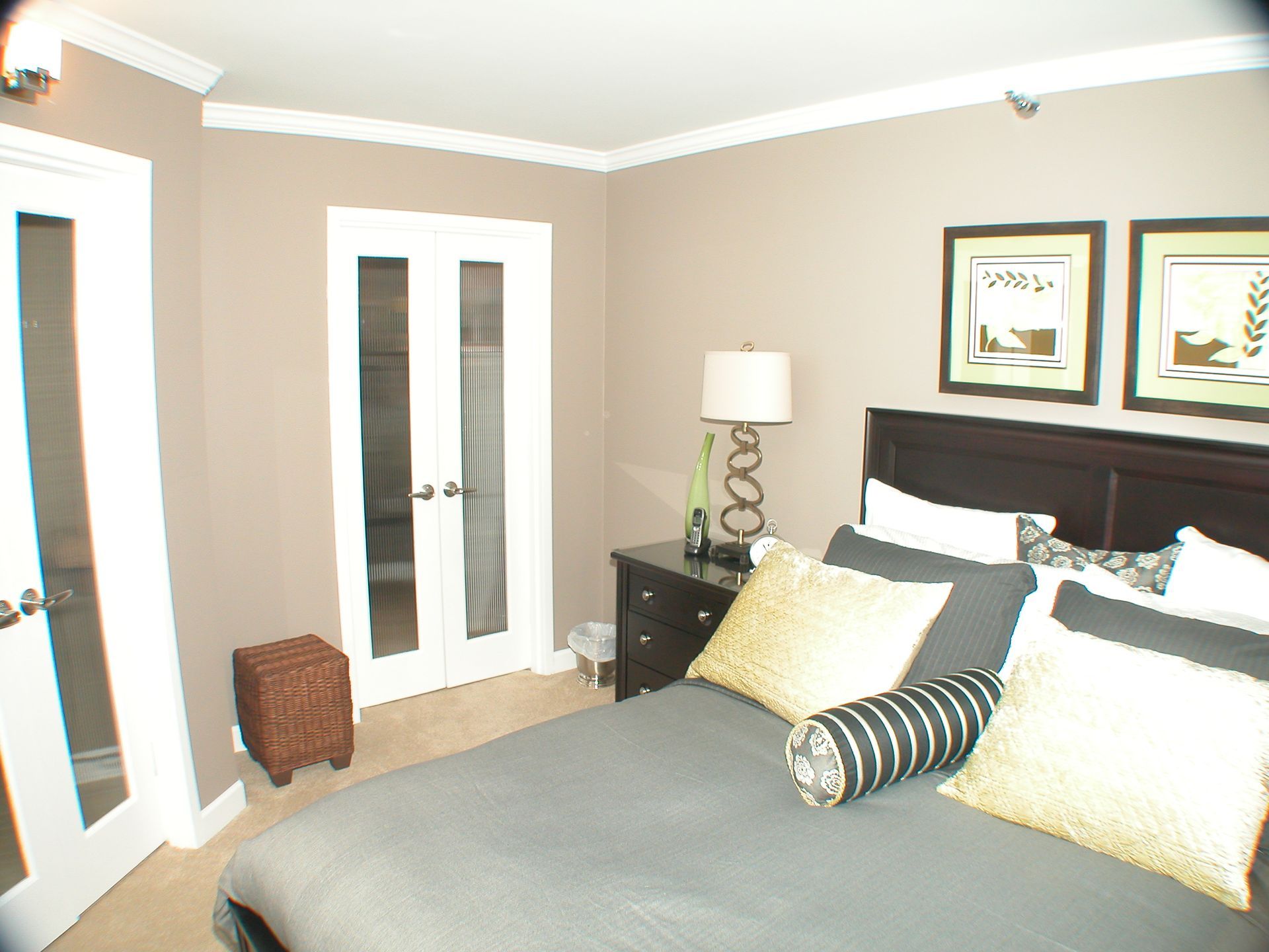 A bedroom with a large bed and a lamp