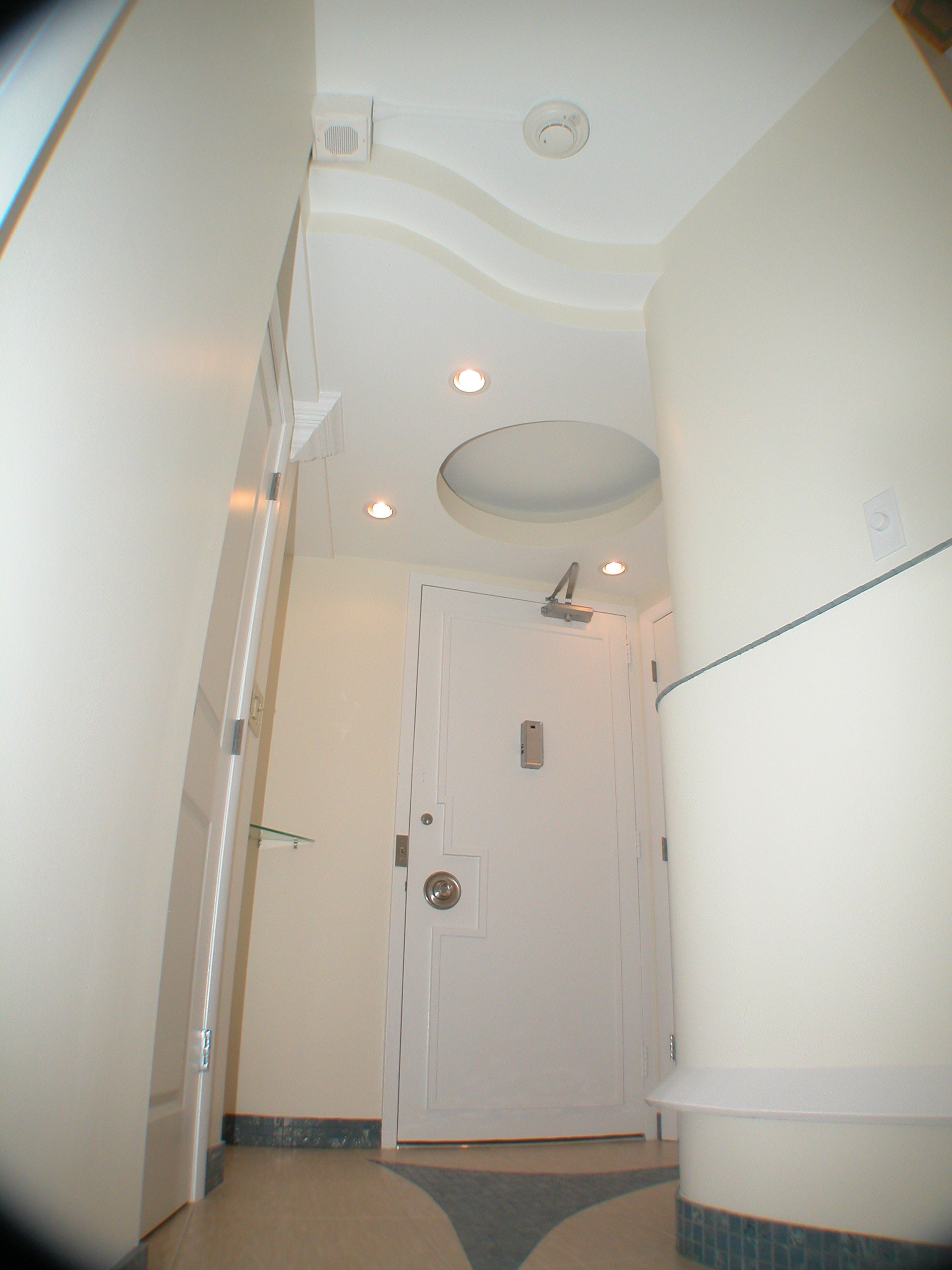 A hallway with a white door and a ceiling light