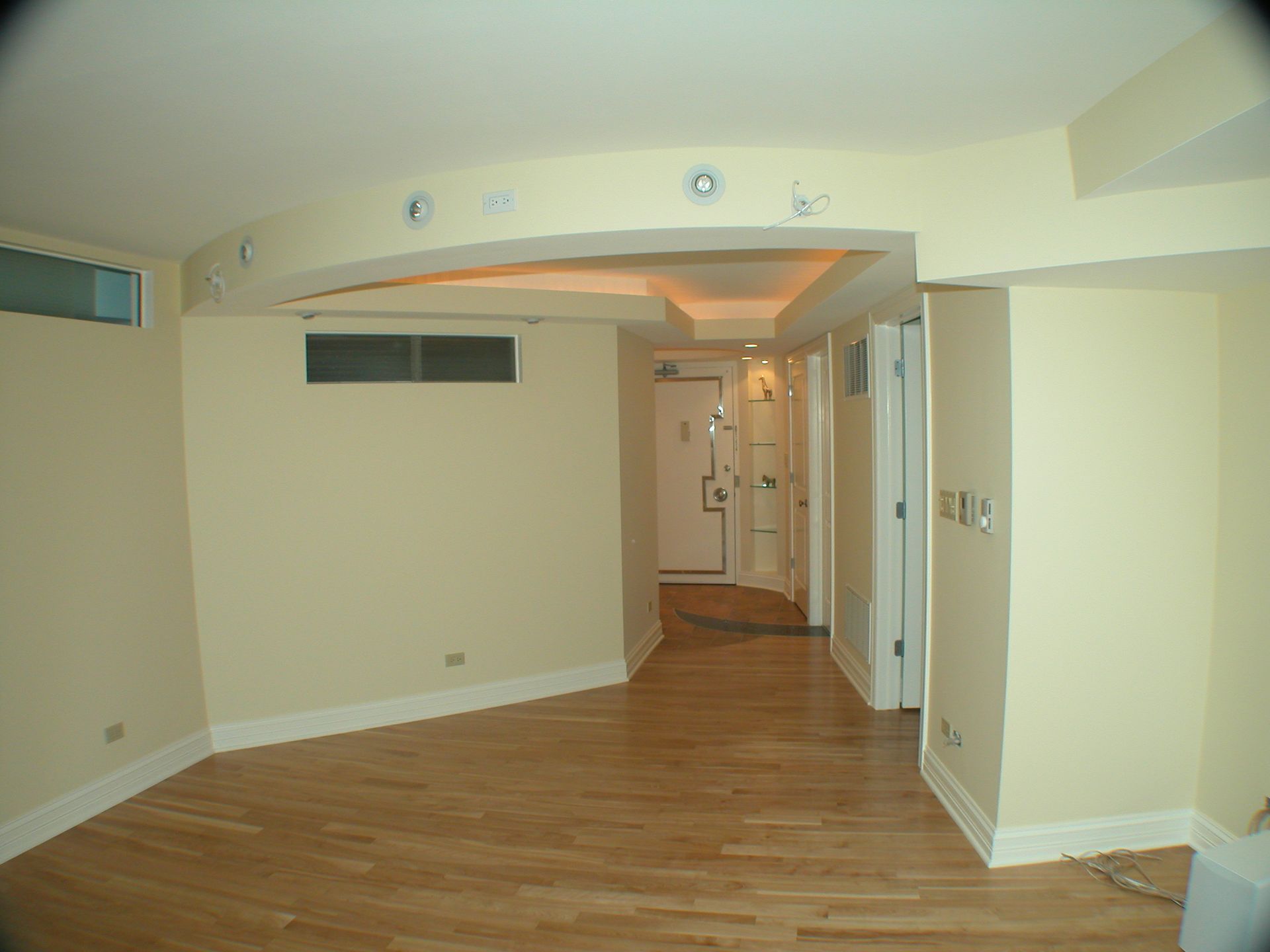 An empty room with hardwood floors and white walls