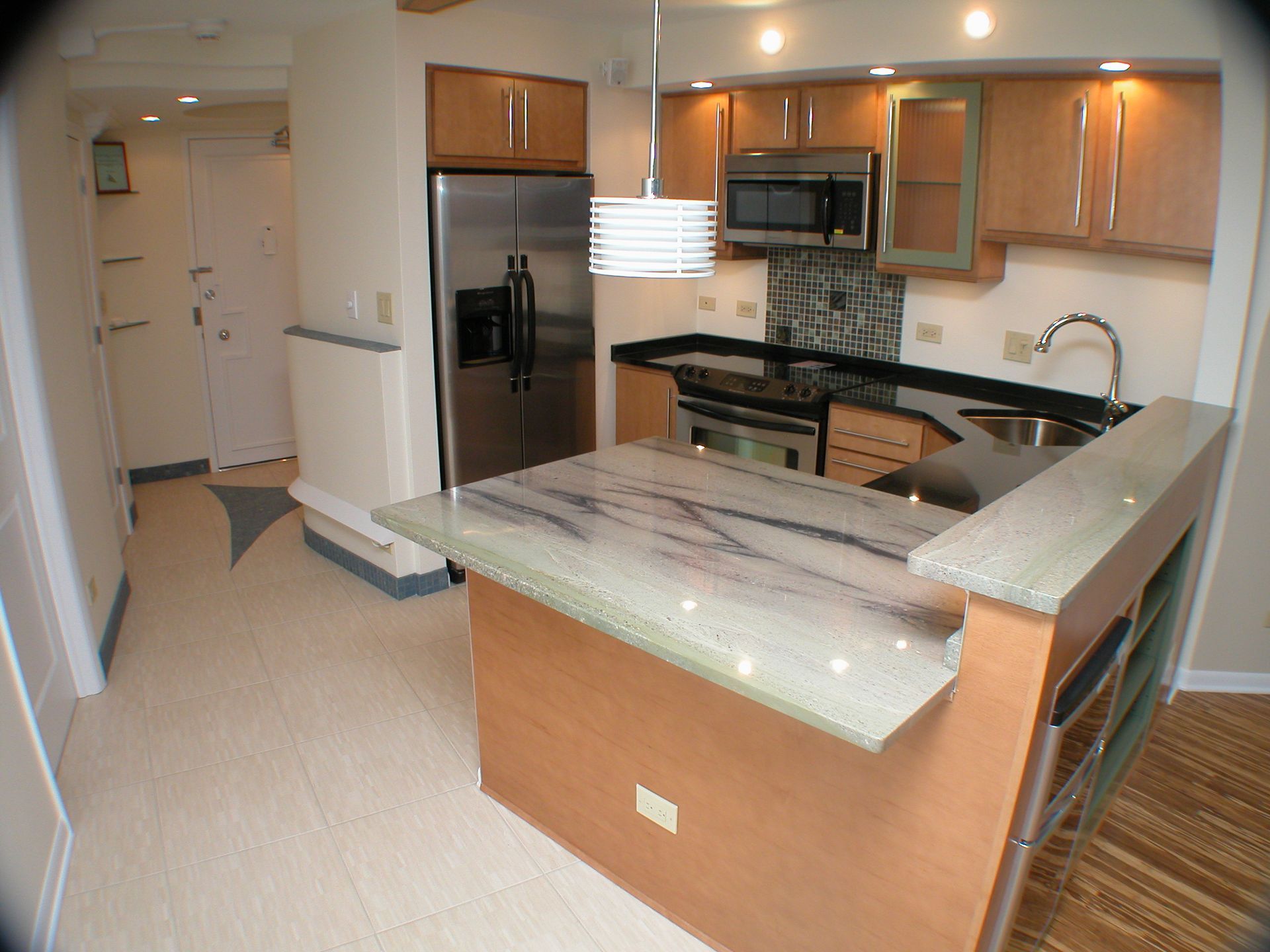 A kitchen with stainless steel appliances and marble counter tops