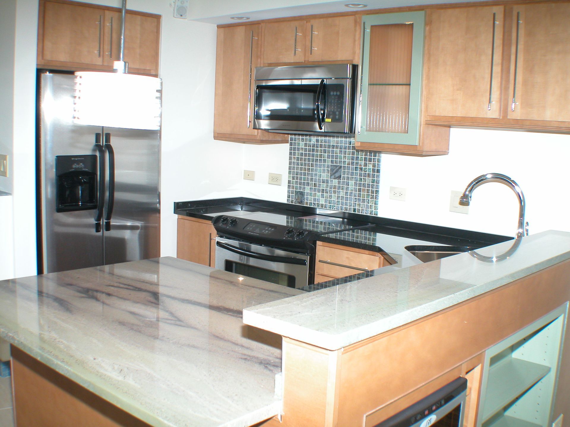 A kitchen with stainless steel appliances and marble counter tops